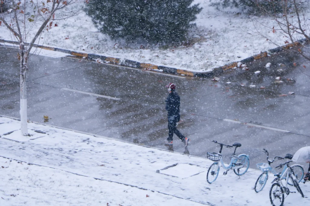Ein verschneiter Gehweg in einer Wohngegend, der auf die Räumpflicht im Winter hinweist.