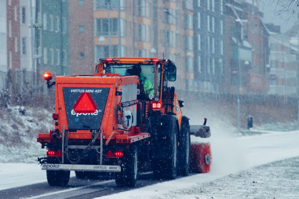 Ein geräumter Gehweg im Winter bei Schneefall